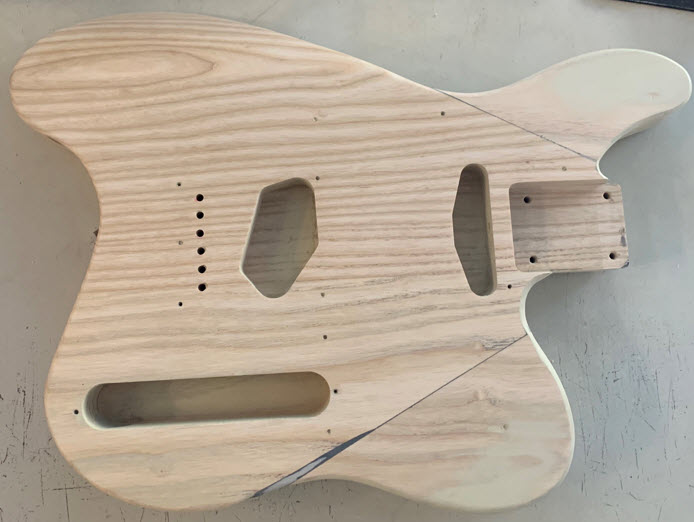 Ergonomic electric guitar body showing the top horns swapped and the cutout in back